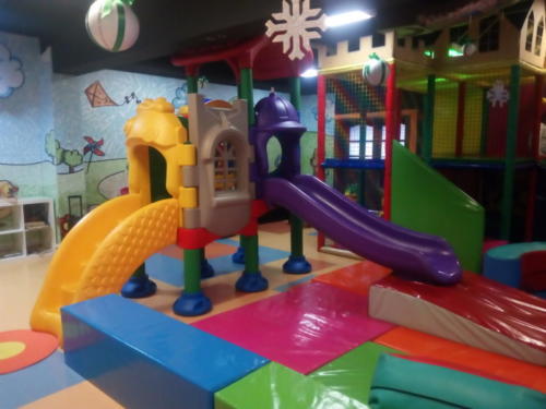 Zdjęcie przedstawia atrakcje znajdujące się w Kąciku Malucha - strefie zabaw dla dzieci do 6 roku życia w Family Park. Na zdjęciu widać zjeżdżalnię oraz basen chiński z piłeczkami.