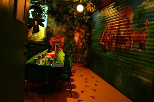 Na zdjęciu widać stół wraz z zastawą oraz dekoracje pokoju Dżungla w Centrum Zabaw Rodzinnych Family Park.